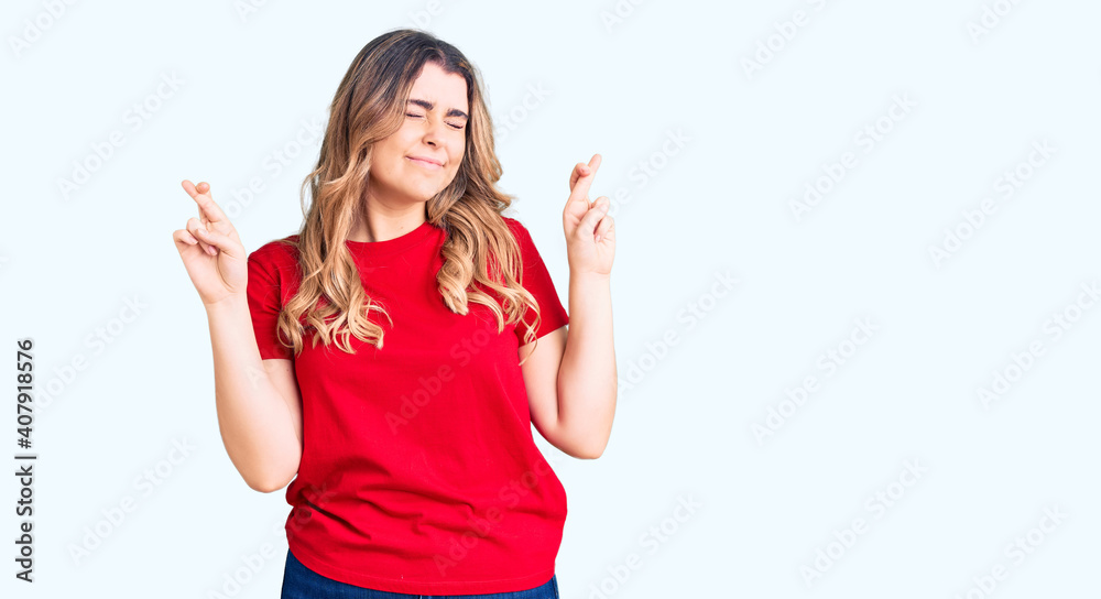 Young caucasian woman wearing casual clothes gesturing finger crossed smiling with hope and eyes closed. luck and superstitious concept.