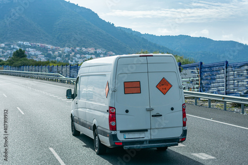 Van transporting explosives, with orange panel and danger labels for expolsion. photo