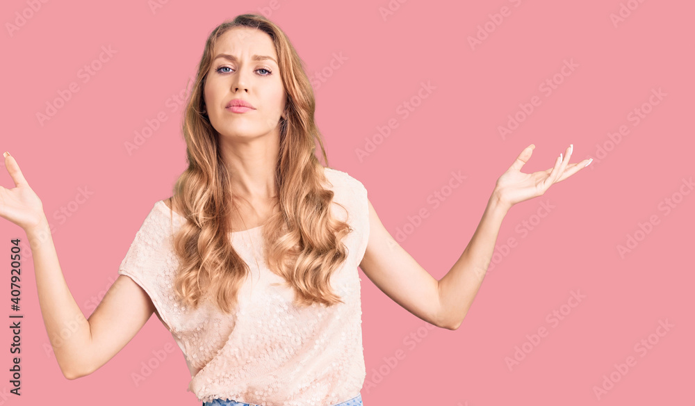 Young beautiful caucasian woman with blond hair wearing casual clothes clueless and confused expression with arms and hands raised. doubt concept. Young beautiful caucasian woman with blond hair wearing casual clothes clueless and confused expression with arms and hands raised. doubt concept.