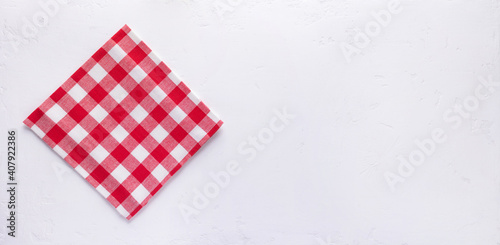 Checked or checkered tablecloth at stone surface of table. Top view of cloth napkin texture background