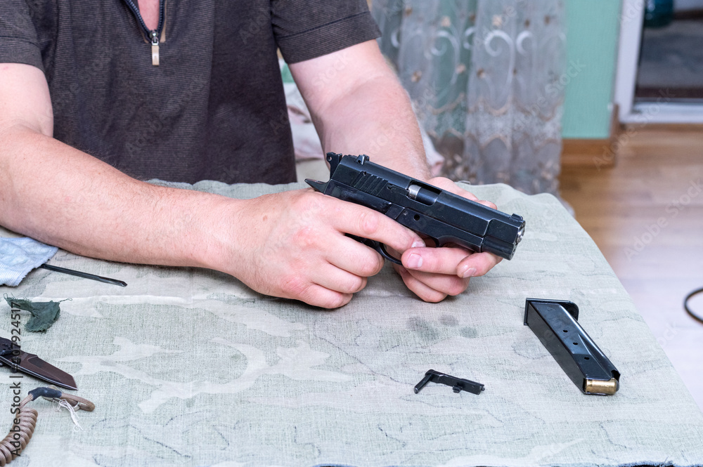 Assembled traumatic pistol. Gun in hand. Gun and parts.