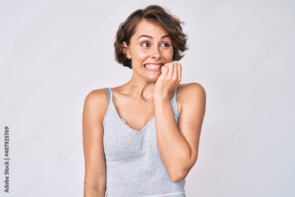 Young hispanic woman wearing casual clothes looking stressed and nervous with hands on mouth biting nails. anxiety problem. Young hispanic woman wearing casual clothes looking stressed and nervous with hands on mouth biting nails. anxiety problem.