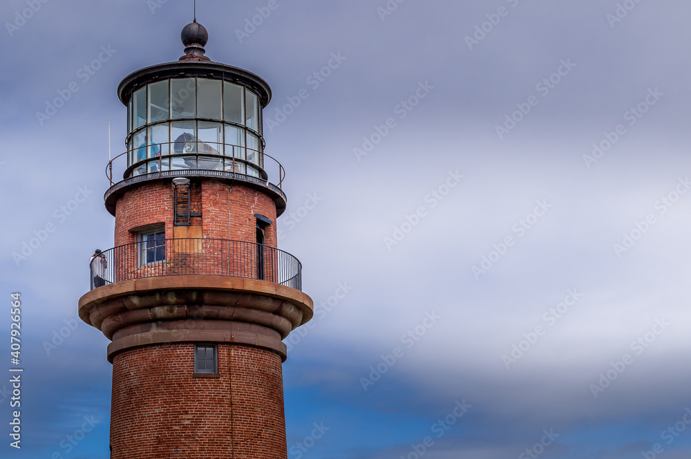 Aquinnah, Massachusetts, USA - Gay Head Light Historic lighthouse in Aquinnah on Martha's Vineyard sits on a hilltop. First in the U.S. to receive a first order Fresnel lens in 1856. Close up view. Aquinnah, Massachusetts, USA - Gay Head Light Historic lighthouse in Aquinnah on Martha's Vineyard sits on a hilltop. First in the U.S. to receive a first order Fresnel lens in 1856. Close up view.