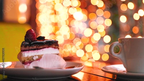 Fruit cake on wooden table with lights in background