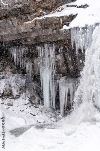 waterfall in the forest during a snowfall in winter