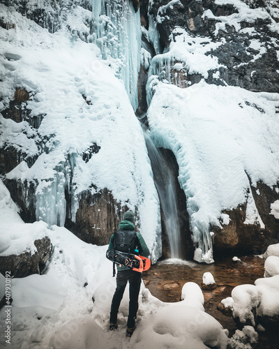 winter landscape forest backpack man / traveler in modern winter clothes in the forest, traveling in the mountains photo