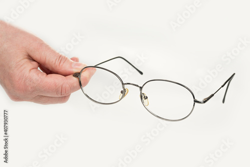 Hand is holding diopter glasses for reading