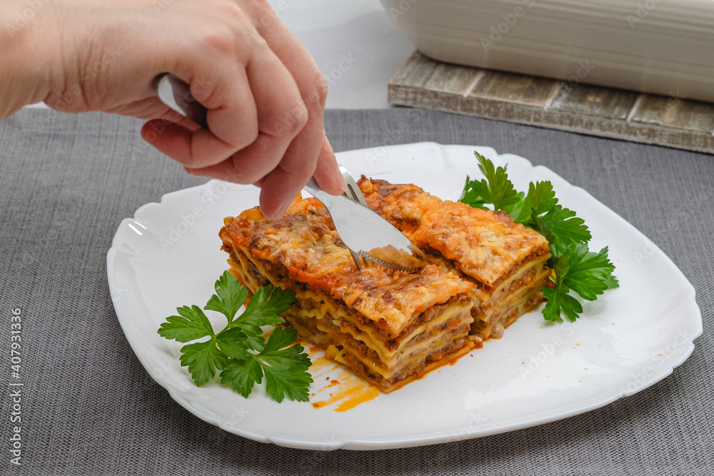Beef lasagna served with fresh parsley close up on plate.
