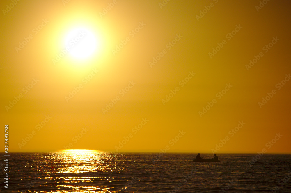 Fishermen on their boat during sunset