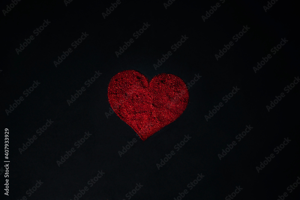 Red heart made of sequins on a black background. Red heart made of sequins on a black background.