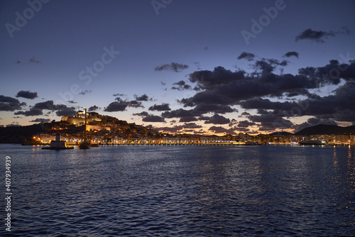 Beautiful shot of the castle and town of Dalt Vila across a lake at sunset photo