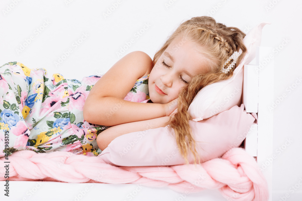 Bedtime. Little girl is sleeping in the bed. Soft bed with pink linen in white bedroom. Child sleep regime hours, daily routine. Sweet dreams concept. Bedtime. Little girl is sleeping in the bed. Soft bed with pink linen in white bedroom. Child sleep regime hours, daily routine. Sweet dreams concept.