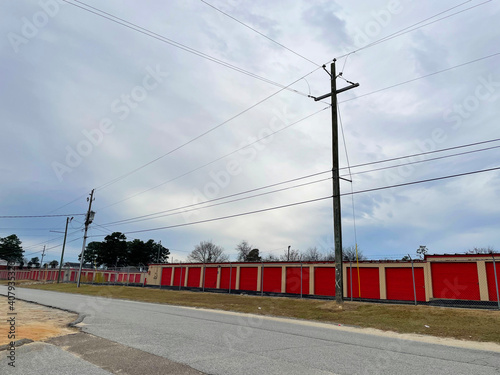 A storage facility with red bay doors and beige trim photo