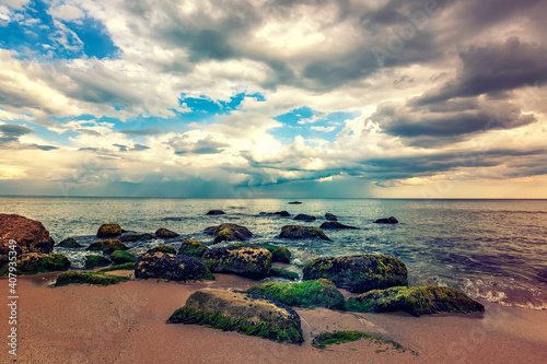 Fototapeta Naklejka Na Ścianę i Meble -  Stone beach. Day view of sea with dramatic sky and clouds. Nature landscape.