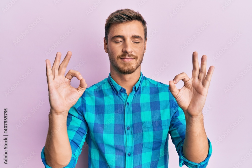Fototapeta premium Handsome caucasian man wearing casual clothes relax and smiling with eyes closed doing meditation gesture with fingers. yoga concept.