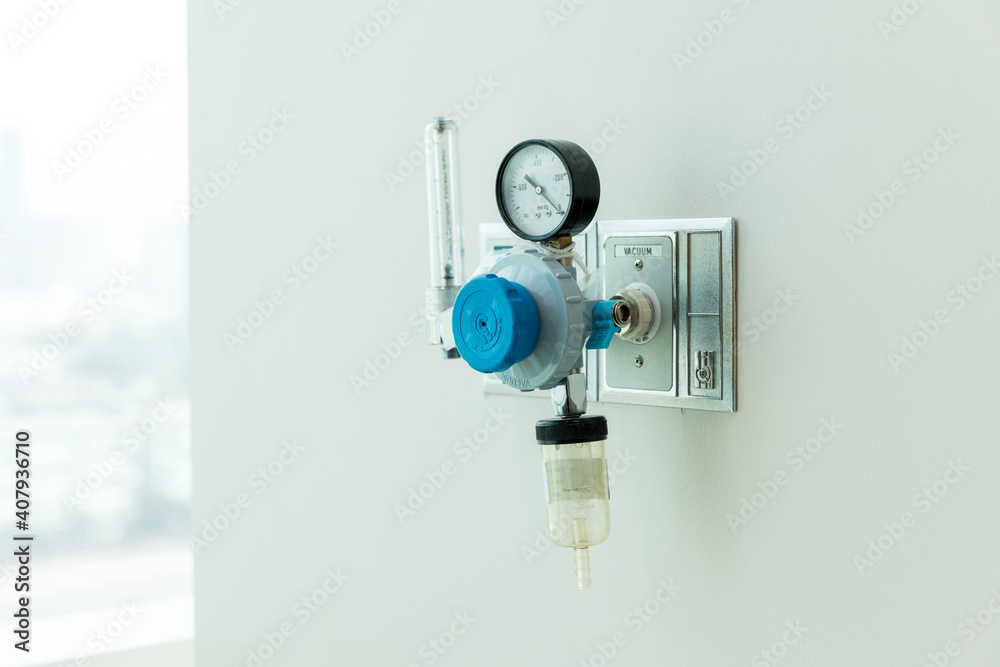 Oxygen flow meter plugged in the green outlet on hospital wall, Medical
