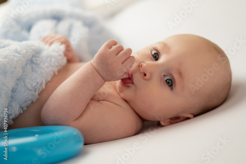baby sucking his thumb on white background