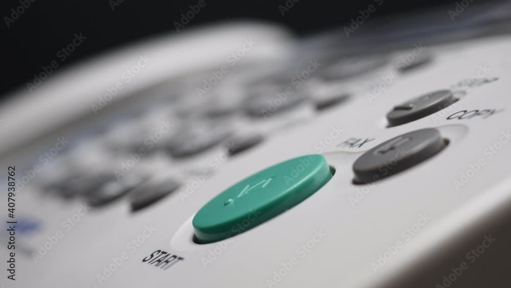 Close Up Of Male Finger Presses The Start Button On White Fax On Black Bokeh Background. Close Up Of Male Finger Presses The Start Button On White Fax On Black Bokeh Background.