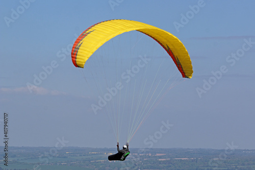 Paraglider flying wing in a blue sky