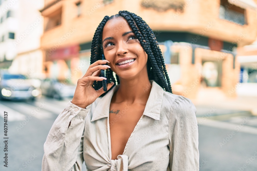 Young african american woman smiling happy talking on the smartphone at the city.