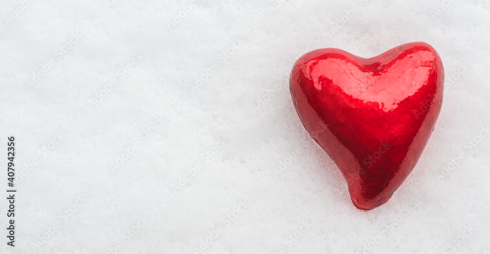 A red heart lies in the snow. Valentine's day background with place for text A red heart lies in the snow. Valentine's day background with place for text