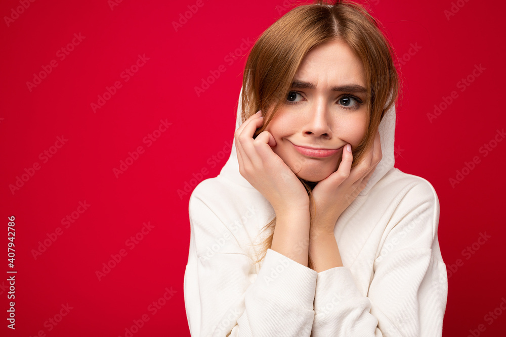 Young dissatisfied tired beautiful dark blonde woman with sincere emotions isolated on background wall with copy space wearing casual white hoodie. Sad concept Young dissatisfied tired beautiful dark blonde woman with sincere emotions isolated on background wall with copy space wearing casual white hoodie. Sad concept