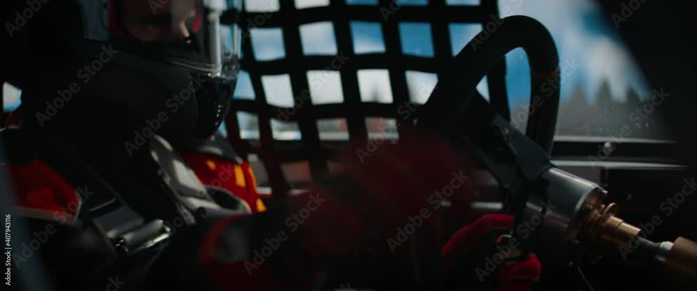 CU View of sports car driver in protective overalls racing on a speedway. Fast speed, motorsport. Daytime shot. Shot with 2x anamorphic lens