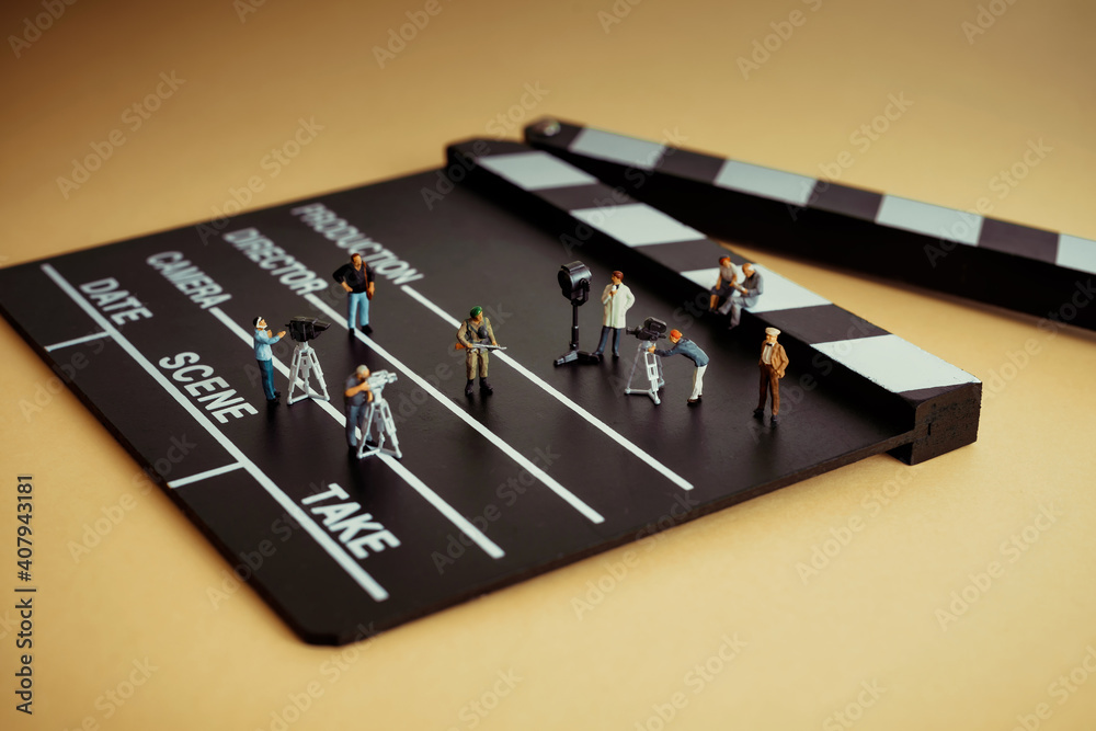 Movie making process. Crew figurines on a wooden clapper Movie making process. Crew figurines on a wooden clapper