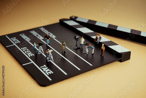 Movie making process. Crew figurines on a wooden clapper