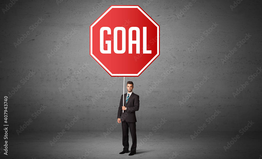 Young business person holding road sign with GOAL inscription, new rules concept Young business person holding road sign with GOAL inscription, new rules concept