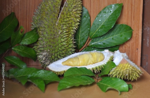 fresh split durian fruit with green leaves