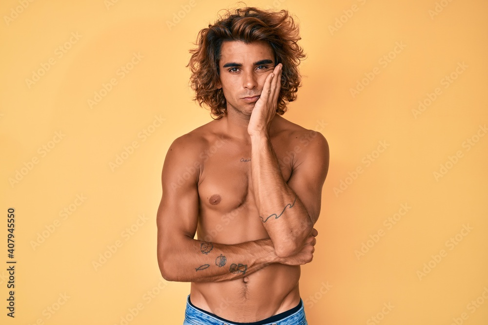 Fototapeta premium Young hispanic man standing shirtless thinking looking tired and bored with depression problems with crossed arms.