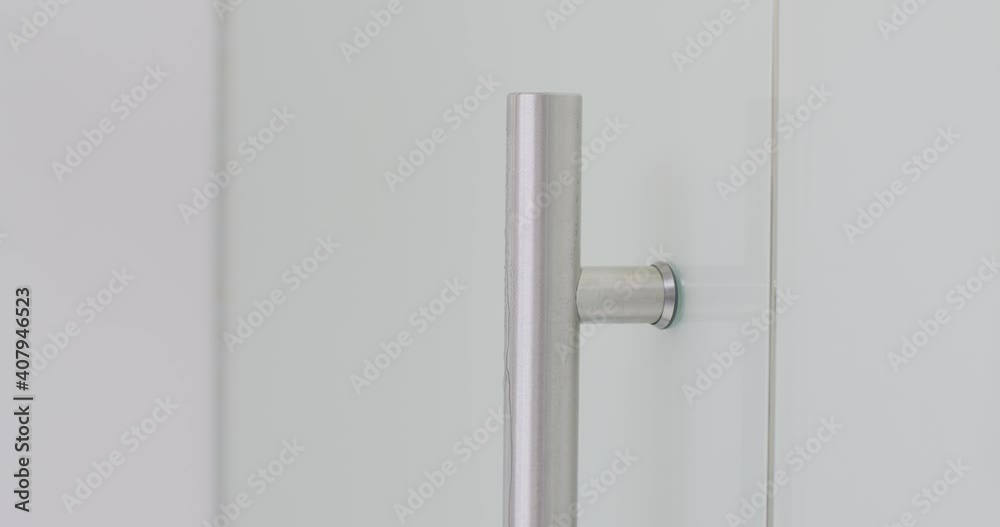 Female hand cleaning and disinfecting office door handle by sanitizer spray and wet wipe to prevent covid-19 Female hand cleaning and disinfecting office door handle by sanitizer spray and wet wipe to prevent covid-19