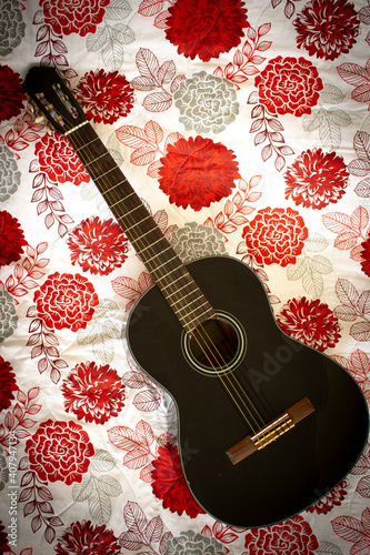 Black guitar on pattern floral background