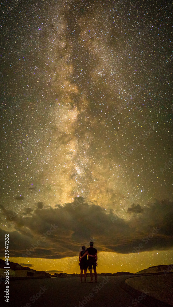 Fototapeta premium Ein Paar Arm in Arm blicken auf die Milchstraße im Death Valley Nationalpark, USA. 