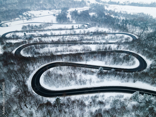 Curvy Winding Road Trough Forest at Winter Season. Aerial Drone Top Down View