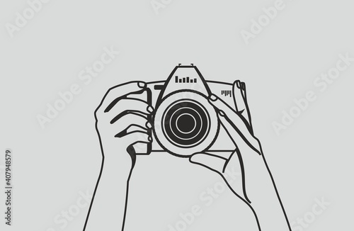 The photographer is holding a camera and is preparing to take a photo. Black vector hands contour on a gray background.