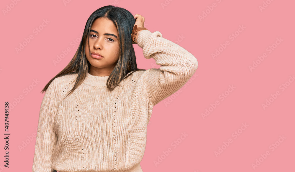 Young latin girl wearing wool winter sweater confuse and wondering about question. uncertain with doubt, thinking with hand on head. pensive concept. Young latin girl wearing wool winter sweater confuse and wondering about question. uncertain with doubt, thinking with hand on head. pensive concept.