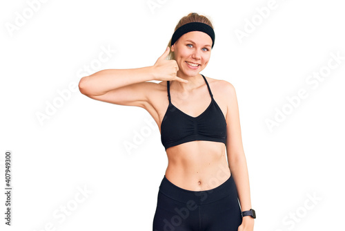 Young beautiful blonde woman wearing sportswear smiling doing phone gesture with hand and fingers like talking on the telephone. communicating concepts.