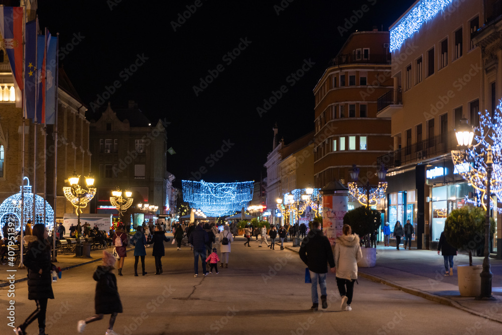 Night images of city center of Novi Sad with building architecture and night life with people selective focus with film grain.
