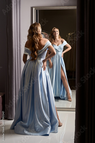 Slika na platnu Young beautiful blonde girl wearing an off-the-shoulder full-length sky blue satin slit prom ball gown