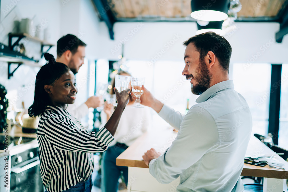 Fototapeta premium Man and African American woman toasting glasses