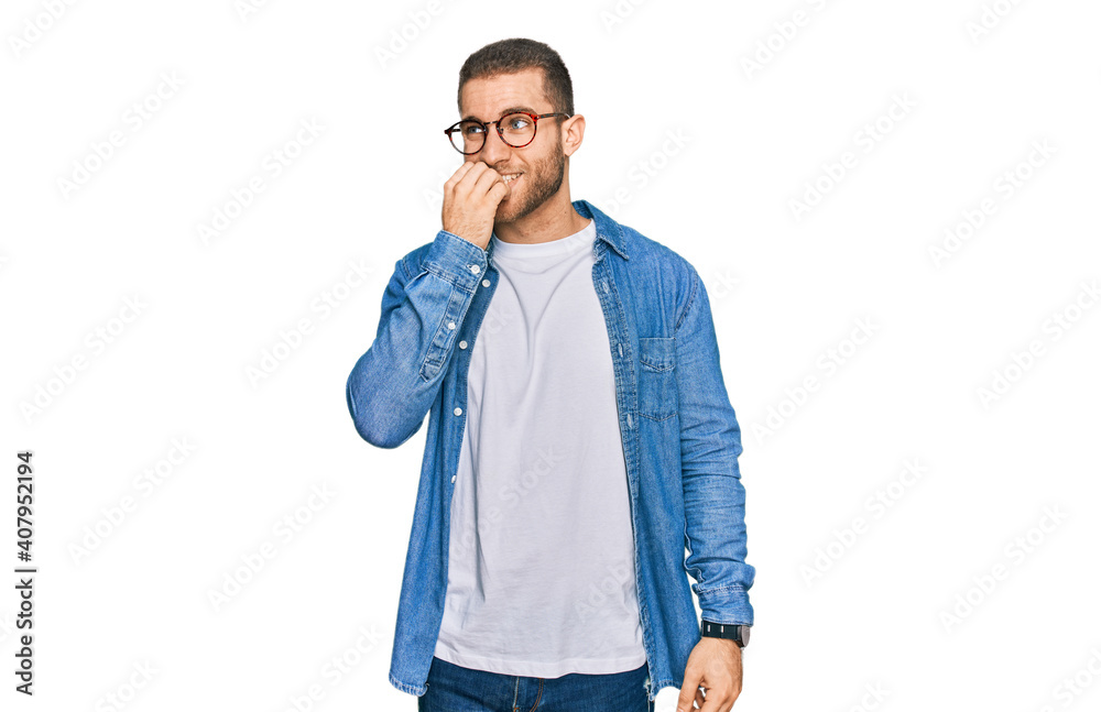 Young caucasian man wearing casual clothes looking stressed and nervous with hands on mouth biting nails. anxiety problem. Young caucasian man wearing casual clothes looking stressed and nervous with hands on mouth biting nails. anxiety problem.