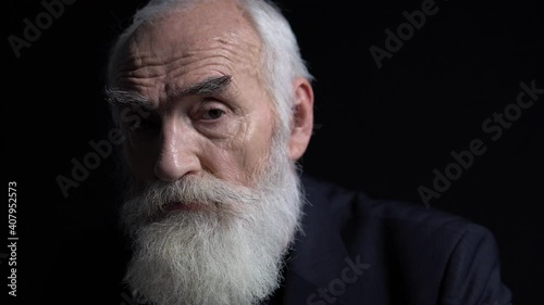 Sad elderly businessman with grey beard looking at camera, work responsibility