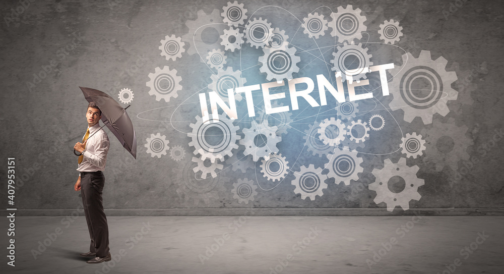 Businessman defending with umbrella from INTERNET inscription, technology concept Businessman defending with umbrella from INTERNET inscription, technology concept