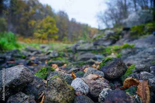 Stones stacked in a hill near the stream. Round stones. granite