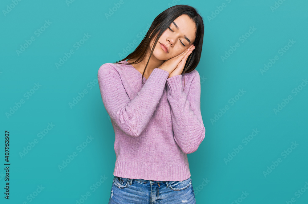 Young hispanic girl wearing casual clothes sleeping tired dreaming and posing with hands together while smiling with closed eyes. Young hispanic girl wearing casual clothes sleeping tired dreaming and posing with hands together while smiling with closed eyes.