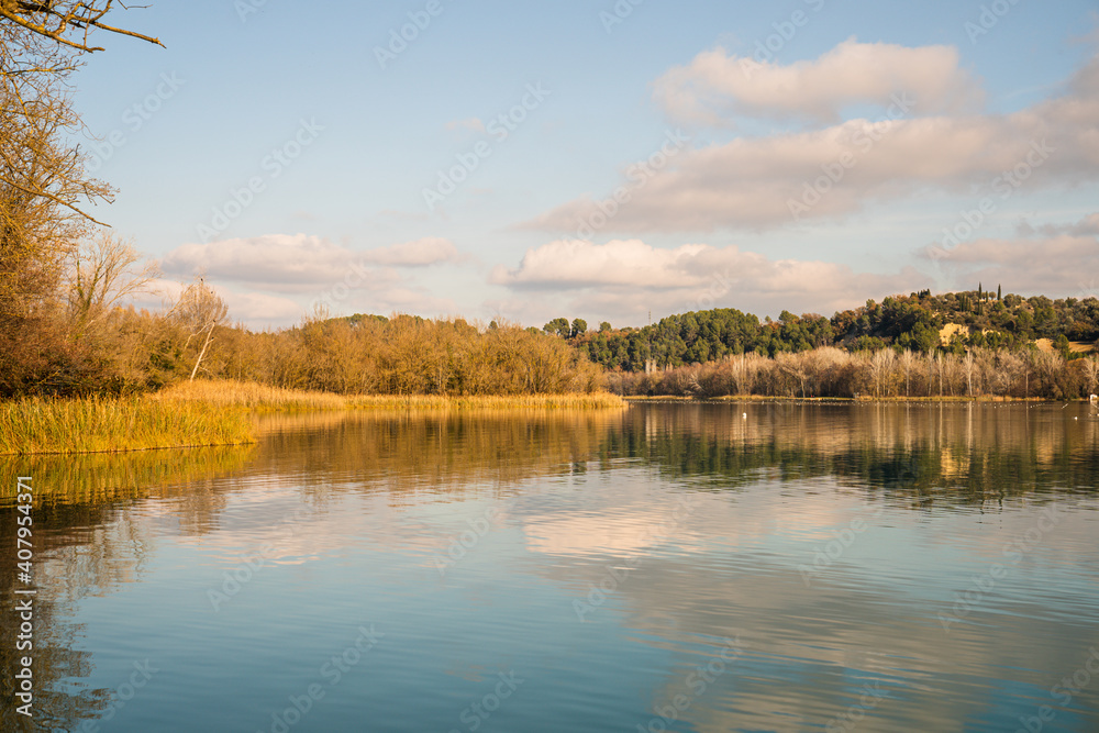 Obraz premium Reflection of the clouds and the blue sky on the water of Lake Banyoles.