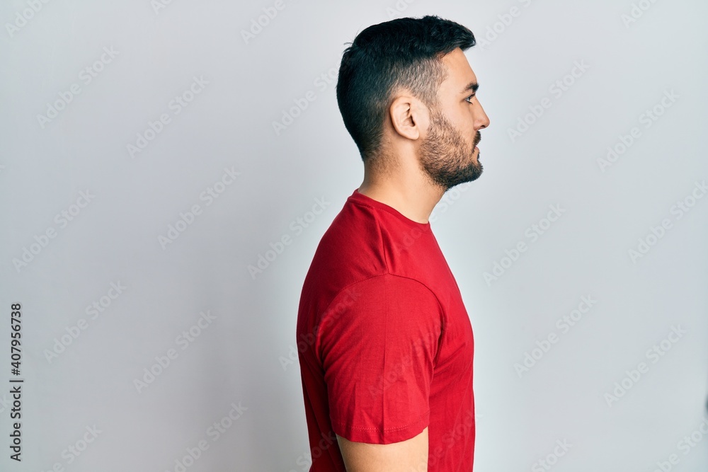 Young hispanic man wearing casual clothes looking to side, relax profile pose with natural face with confident smile.