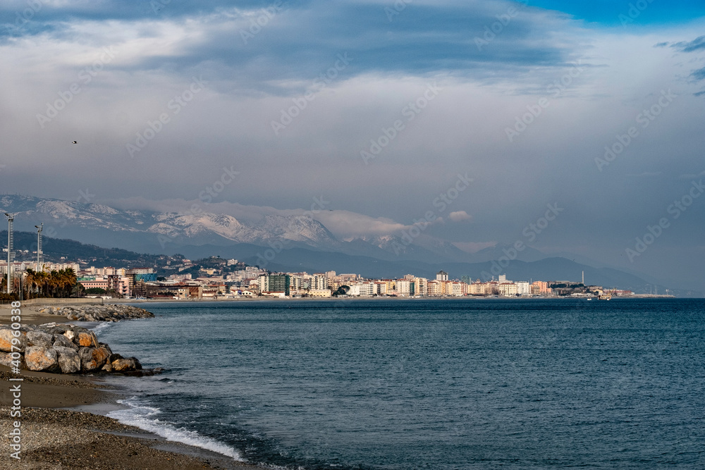 sea ​​landscape and snow capped mountains in the background on a January winter day